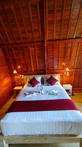 a bedroom with a large bed with red pillows at Green Pacing Lodge in Bangli
