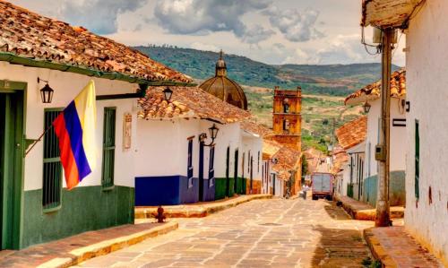an alley in an old town with a tower at Hotel Mision Santa Barbara RNT 4799 in Barichara