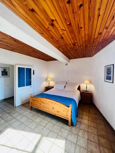 une chambre avec un lit avec un plafond en bois dans l'établissement Le Portail Neuf, à Beaumes-de-Venise