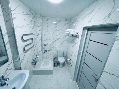 Un baño blanco con lavabo e inodoro. en COZY Apartment in Bukhara !, en Bukhara