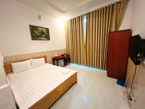 a bedroom with a bed and a television in it at Khách Sạn Thiên Phúc in Ho Chi Minh City