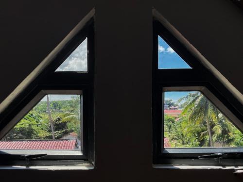 two windows in a room with a view of palm trees at Seashell Guesthouse, bar and tattoos in Koh Rong Sanloem