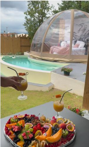 a plate of fruit on a table next to a pool at Le Clos FMR Insolite - "F"anny Carcassonne in Malves-en-Minervois