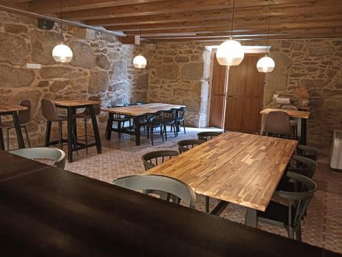 a row of tables and chairs in a room with stone walls at Quinta Pazo Corisca in Salceda