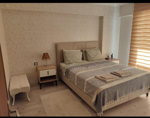 a bedroom with a bed and a table and a lamp at Eryaman, Wide Luxury Concept in Etimesut