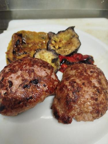 a white plate of food with meat and vegetables at Albergo Le 2 Rose in San Severino Marche