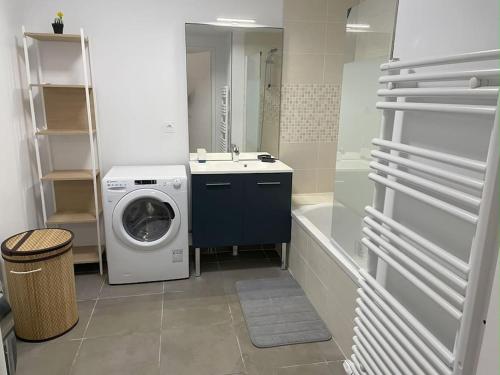 a bathroom with a washing machine and a sink at L'appartement Bleu-T2-Annemasse in Annemasse