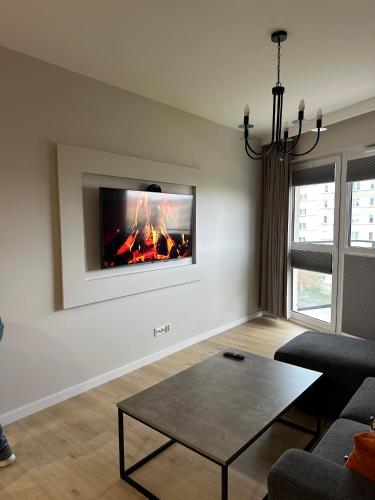 a living room with a fire place on the wall at Apartament M&A in Łomża