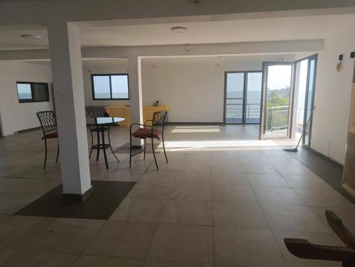 a living room with a table and chairs and a balcony at Monte village Guest House in Beira
