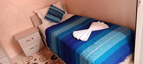 a bedroom with a blue and white bed with two pillows at Mirleft Tayought Guest House in Mirleft