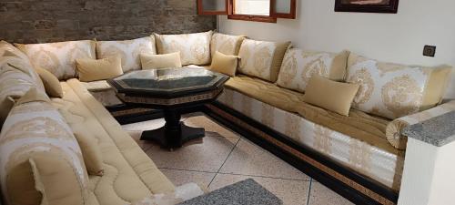 a long couch with a table in a room at Mirleft Tayought Guest House in Mirleft