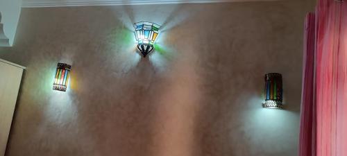 two lights on a wall in a room at Mirleft Tayought Guest House in Mirleft