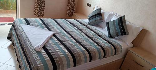 a bed with a comforter and pillows on it at Mirleft Tayought Guest House in Mirleft