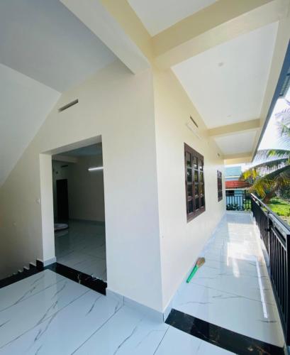 a hallway of a house with white walls and white floors at Hisham Residency Anex in Kakkanad