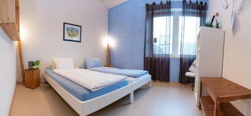 Una pequeña habitación con una cama y una ventana. en BnB Entensee, en Uznach