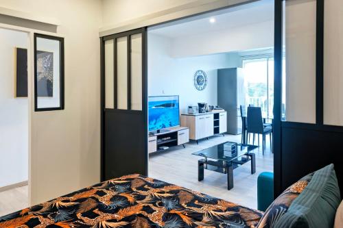 a bedroom with a bed and a living room at Caribbean Escape Coco & Mango in Baie Nettle