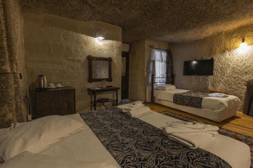 a hotel room with two beds and a television at Century Cave Hotel in Goreme