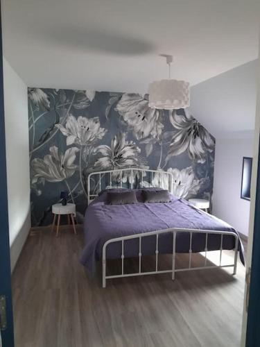- une chambre avec un lit violet et un papier peint floral dans l'établissement Gîte du Grand Val, à Champosoult