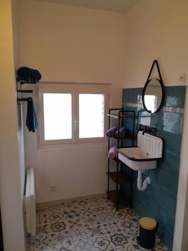 une salle de bain avec un lavabo et un miroir dans l'établissement Gîte du Grand Val, à Champosoult