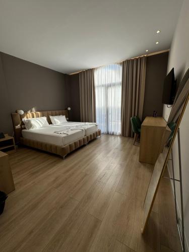 a bedroom with a bed and a large window at Hotel Panorama & Spa Elbasan in Elbasan