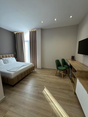 a bedroom with a bed and a flat screen tv at Hotel Panorama & Spa Elbasan in Elbasan