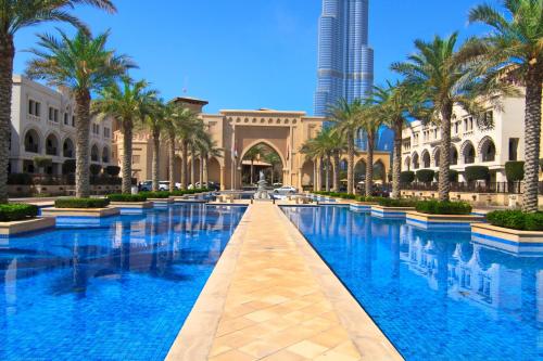 a pool in the middle of a building with palm trees at Lux Sky Residence, Burj Crown, Opera Boulevard View by Dubai Mall in Dubai