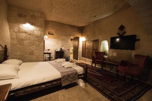 a bedroom with a bed and a flat screen tv at Century Cave Hotel in Goreme