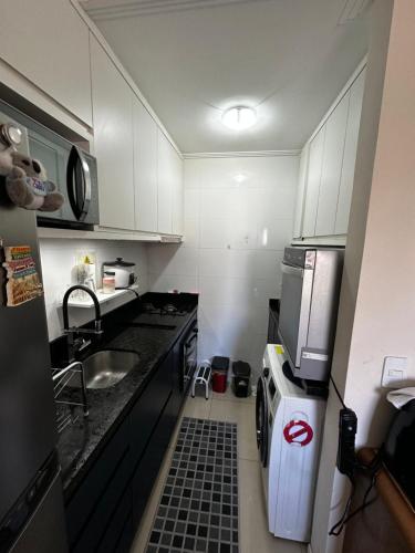 a small kitchen with a sink and a microwave at Hostel APÊ DO CRIS in Florianópolis