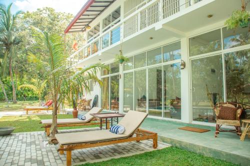 a house with a patio with chairs and a table at CJ's House at Mawella in Mawella