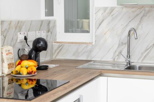 a kitchen counter with a sink and a plate of fruit at kensington in St. Paul's Bay