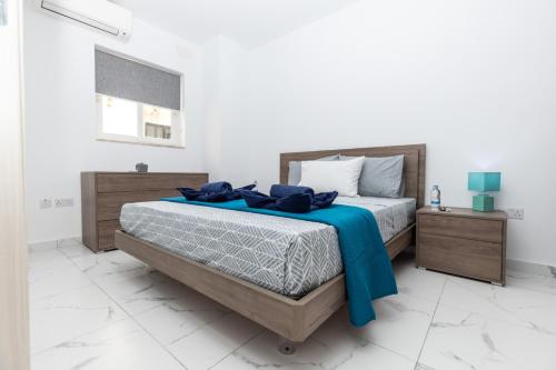 a bedroom with a bed with a blue blanket on it at kensington in St. Paul's Bay