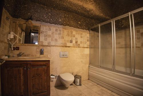 a bathroom with a toilet and a shower and a sink at Century Cave Hotel in Goreme