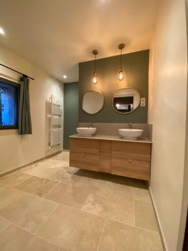 une salle de bain avec deux lavabos et deux miroirs dans l'établissement Mas Familial avec piscine, à Avignon