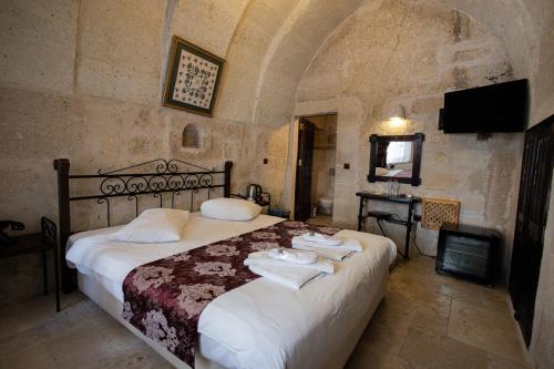 a bedroom with a bed with towels on it at Century Cave Hotel in Goreme