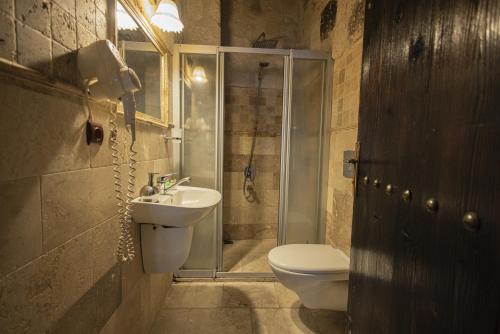 a bathroom with a toilet and a sink and a shower at Century Cave Hotel in Goreme