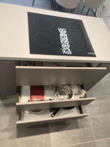 a white table with a drawer with dishes on it at Swiss Star Apartment in Mosonmagyaróvár