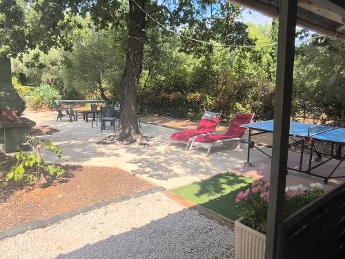 a patio with a table and chairs and a tree at VILLA TERRE NEUVE in Signes