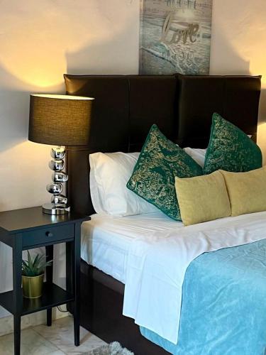 a bed with a brown headboard and a table with a lamp at AD house on Carvoeiro in Carvoeiro