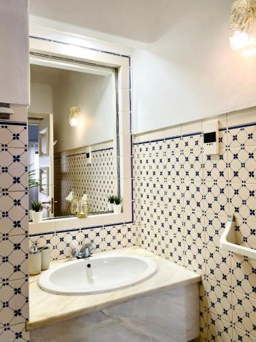 a bathroom with a sink and a large mirror at AD house on Carvoeiro in Carvoeiro