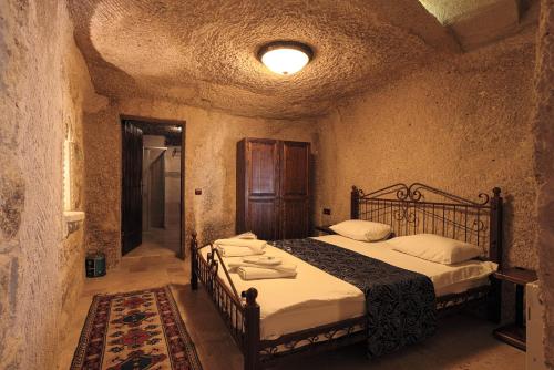 a bedroom with two beds in a stone room at Century Cave Hotel in Goreme