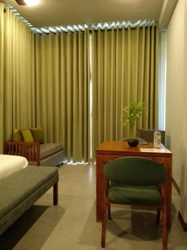 a bedroom with a bed and a desk and a chair at Villa Rumassala Luxury Chalets Unawatuna in Unawatuna