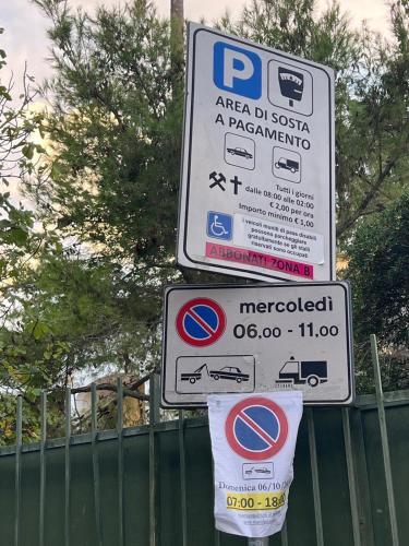 a parking signs on a pole next to a fence at Casa Vacanza IMPARO B&B Ischia in Ischia