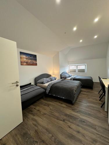 シュターデにあるGästehaus Bützfleth, Rad-Hotel, Arbeit & Privat, Bed & Breakfast, Mitten am Elb-Rad-Wanderwegのベッドルーム(ベッド3台、テーブル付)