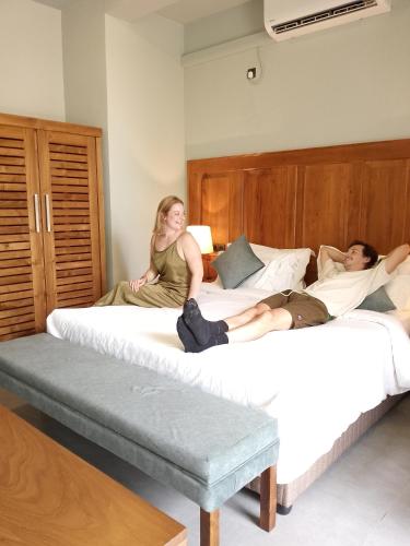 two people sitting on beds in a bedroom at Villa Rumassala Luxury Chalets Unawatuna in Unawatuna