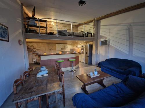 a living room with a table and a blue couch at Loft in Aujeurres