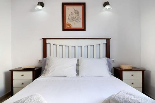 a bedroom with a white bed with two night stands at Casa Luisa Anclada frente al mar in Arrieta