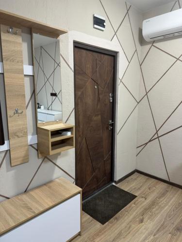 a bathroom with a wooden door and a mirror at Family Hotel in Novomoskovsʼk