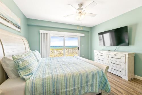 a bedroom with a bed and a flat screen tv at Portside Villa, No 36 Pet Friendly Beachfront Paradise Retreat in Pensacola Beach