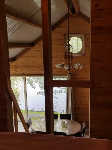 a dining room with a table and a chandelier at Huisje aan het water in Lichtervelde