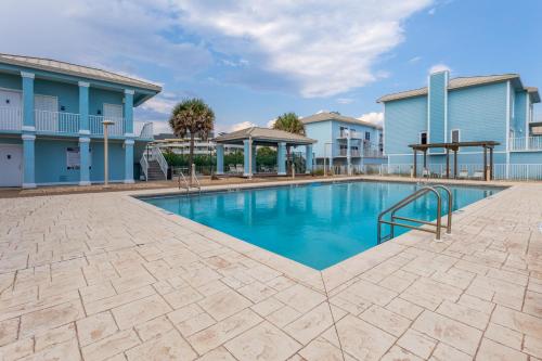 a swimming pool in front of a building at Portside Villa, No 36 Pet Friendly Beachfront Paradise Retreat in Pensacola Beach